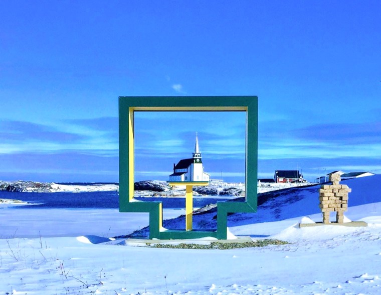Anglican church in Newtown, Newfoundland framed by an outdoor bench in winter